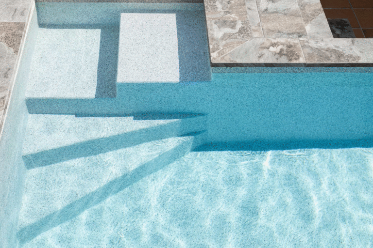 Escaleras, iluminación y coronas: detalles que transforman una piscina vieja