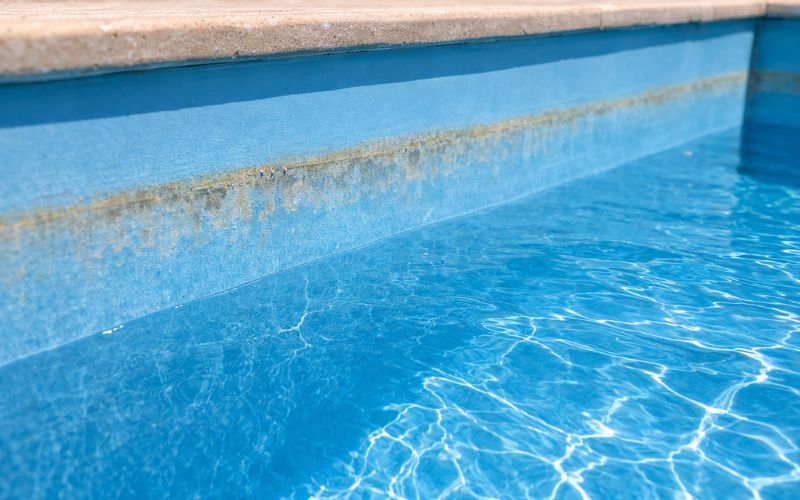línea de agua de piscina con desgaste en el revestimiento