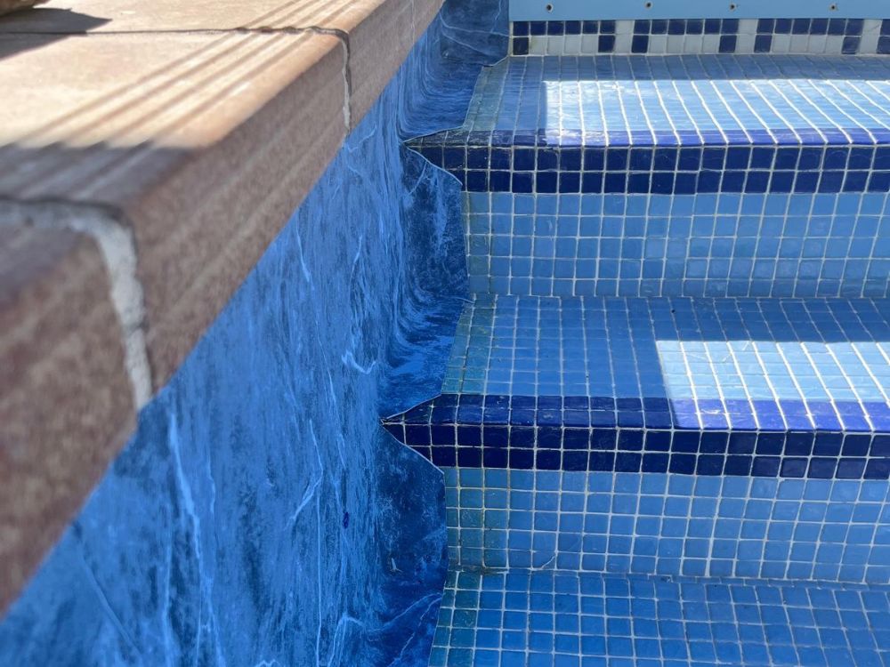 Detalle del perfil bajo la coronación de una piscina para explicar cómo se fija la lámina armada.